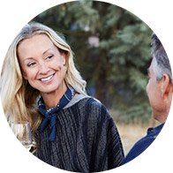  Kvinna och man som samtalar utomhus i en lugn miljö, bra för att minimera bakgrundsljud och främja hörselhälsa.