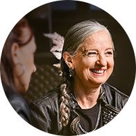  Kvinna med flätat hår som diskuterar sina Oticon Intent hörapparater och förbättrad lyssningskomfort.