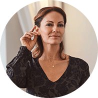  Kvinna justerar sina Oticon Real hörapparater, med innovativ teknik.