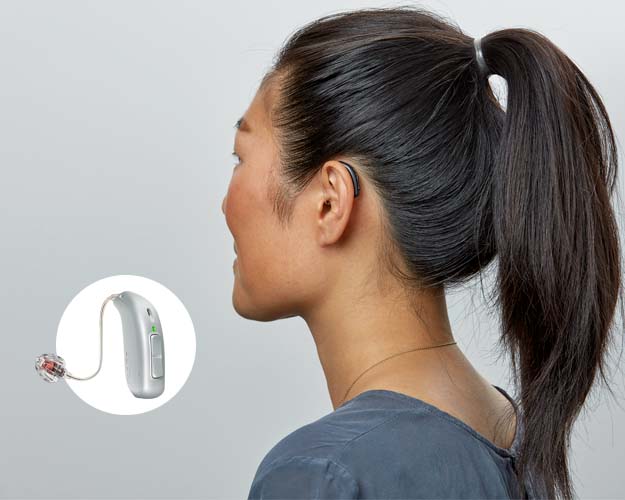 Kvinna som bär hörapparat från regionens upphandlade sortiment