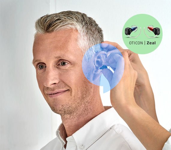 En man som provar ut en nästan osynlig hörapparat som heter Oticon Zeal hos Audika