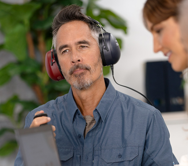 Man som gör hörseltest hos audionom