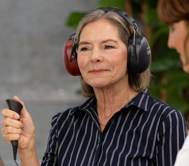 Bild på en kvinna som gör ett hörseltest hos Audika