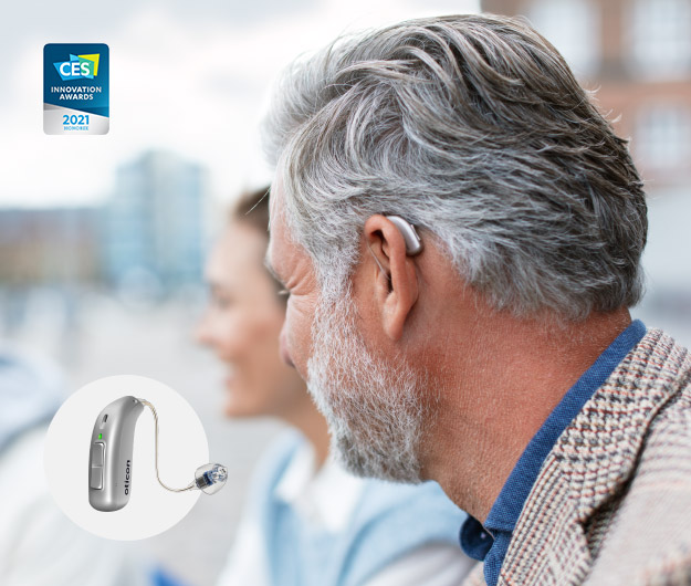 Bild på man med hörapparat som är uppladdningsbar. Hörapparaterna har laddningsbara batterier.