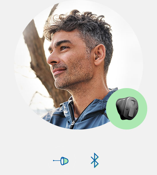 Bild på en man som har en Oticon Own hörapparat