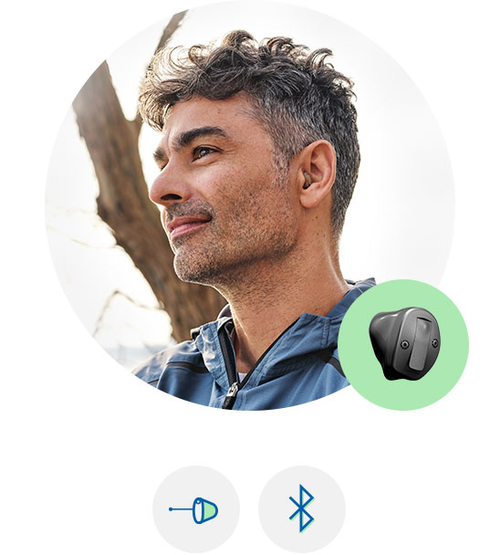 Bild på en man som har en hörappat som heter Oticon own på sig