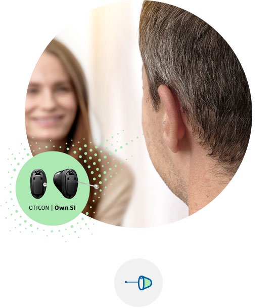En man som en hörapparat Oticon Own Si som sitter i örat. 