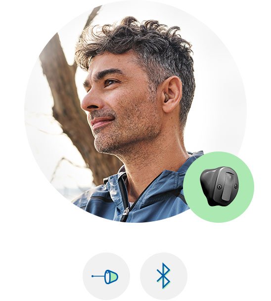  Man med Oticon Own-hörapparat i örat.