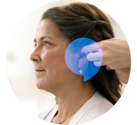  Kvinna får hjälp med utprovning av hörapparat hos Audika.