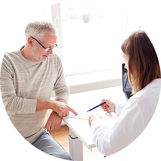  Man diskuterar resultat av hörseltest med en audionom.