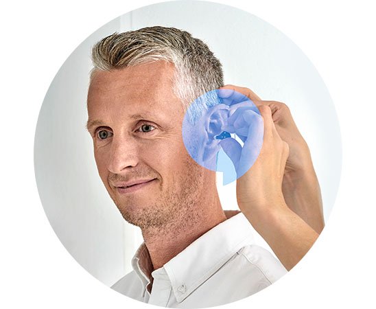 Man som provar ut hörapparater efter individanpassad hörselvård hos Audika