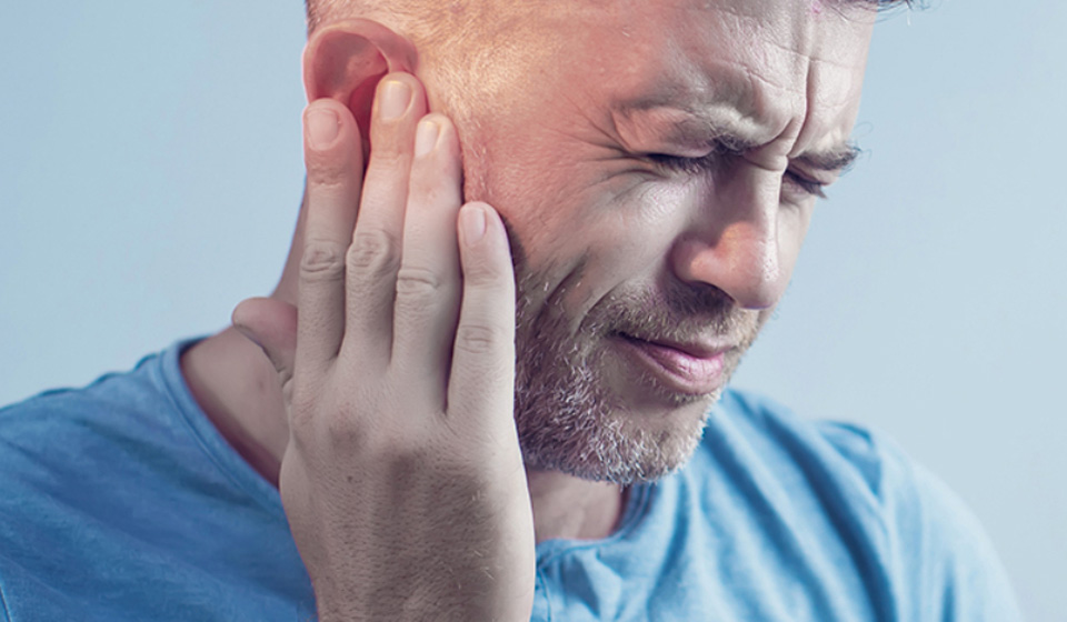 Man experiencing tinnitus symptoms and searching for a potential cure.
