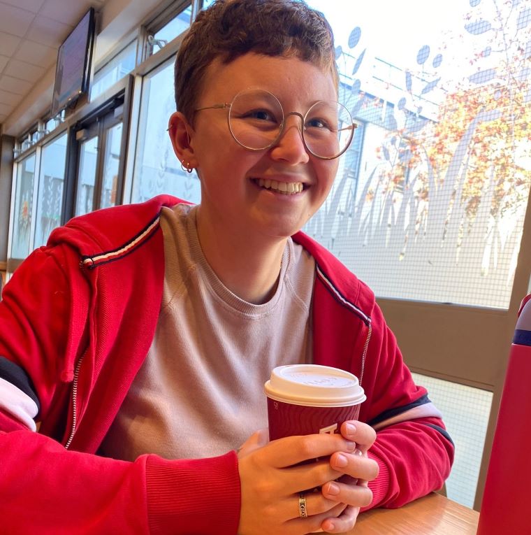 Audika give back programme participant enjoying coffee indoors.