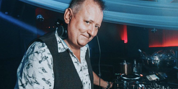DJ wearing hearing aids while performing at an indoor event.