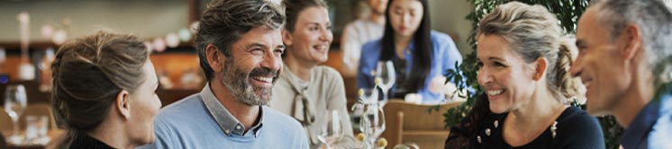 Man with hearing aids enjoying a conversation at a lively restaurant.