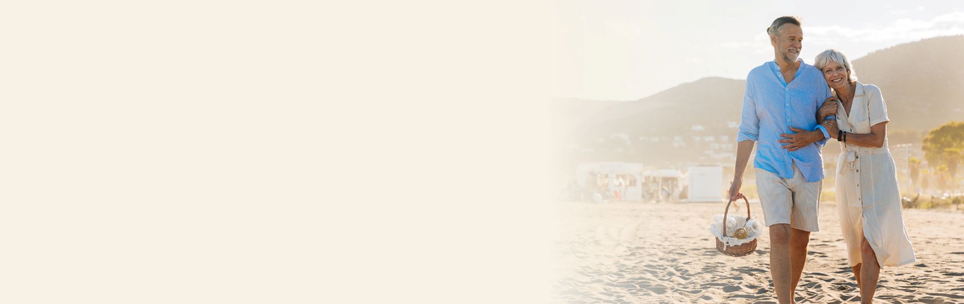 A man and woman with hearing loss walk along a beach