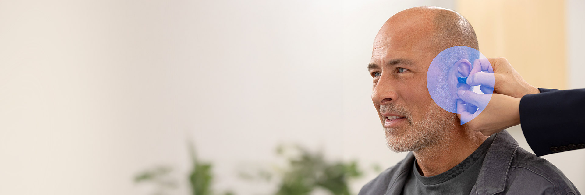 Man receiving professional hearing aid fitting from Audika