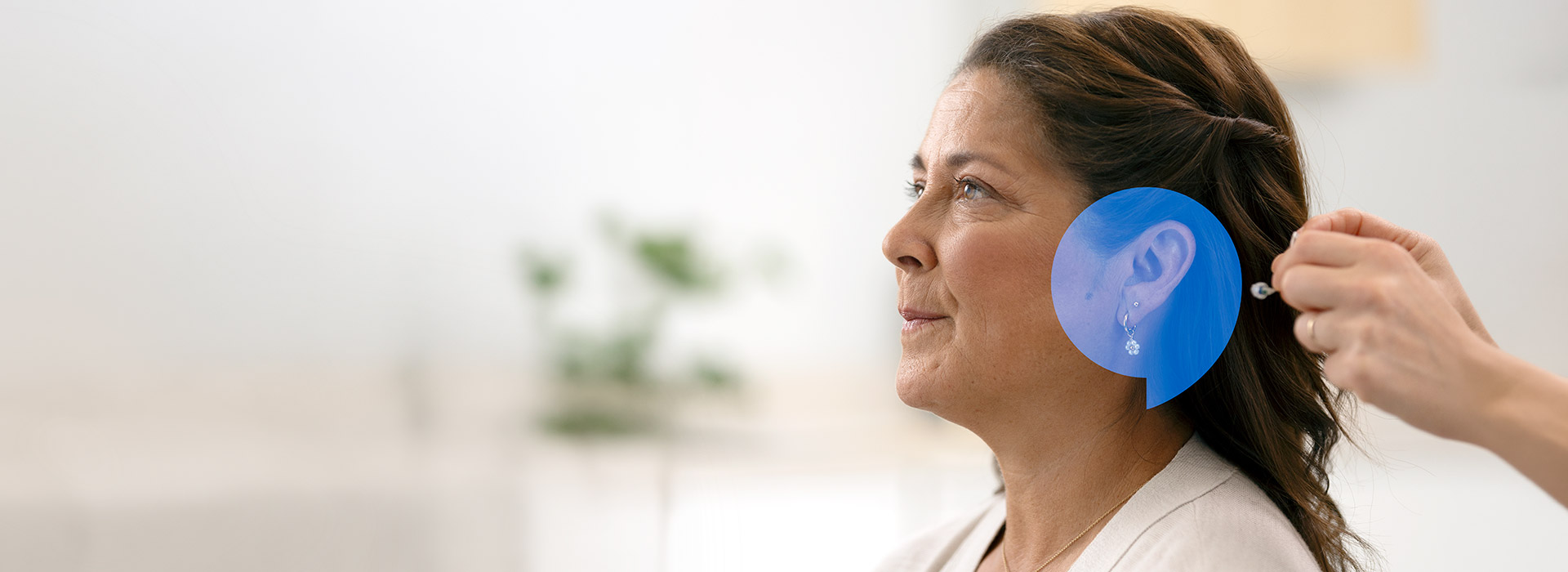 A lady gets a hearing aid fitted by a Audika audiologist