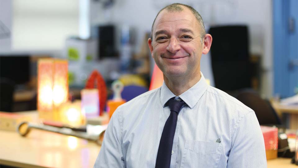 Audika customer Alex Slight in an office setting