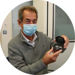 Audika ambassador Steve Parrish showcasing a hearing aid in its case