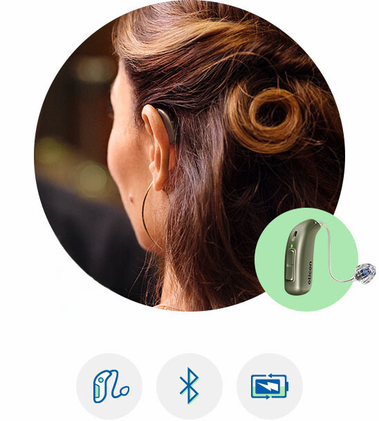 Oticon Real hearing aid worn discreetly behind the ear, highlighting modern hearing technology features like Bluetooth connectivity and rechargeable batteries.