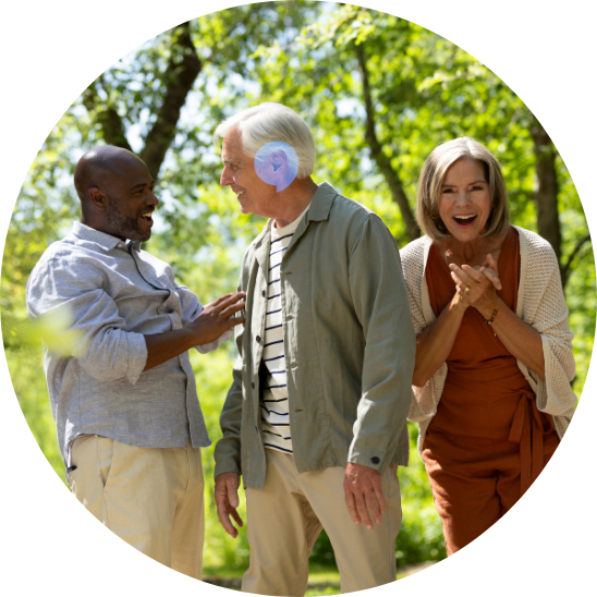 Group of elderly friends enjoying a conversation outdoors, emphasizing hearing care and connection.