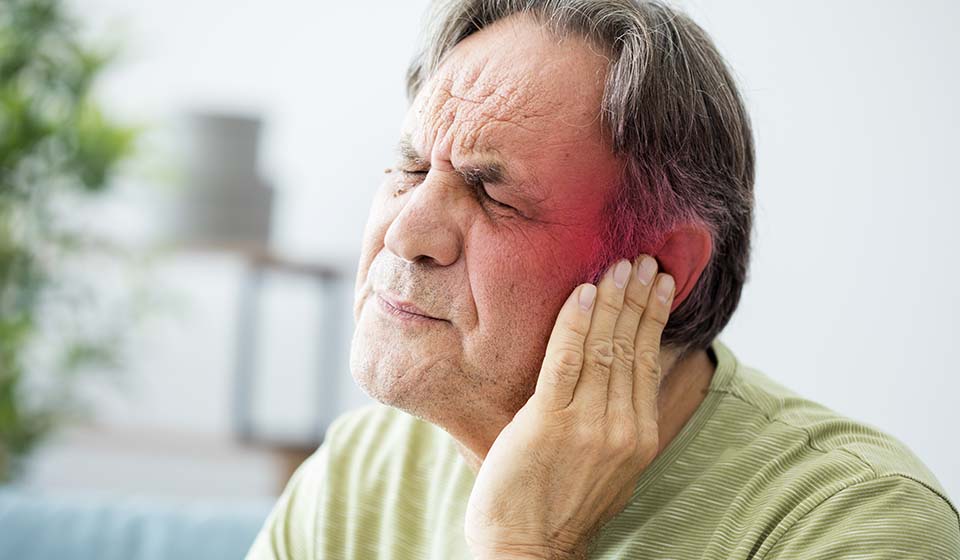 tinnitus man holding ear