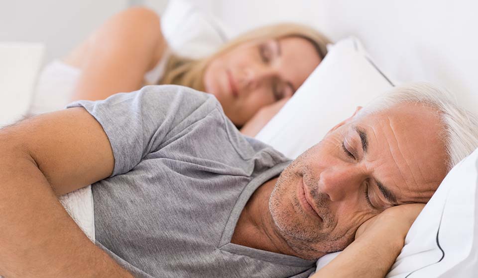 man and woman sleeping peacefully in bed
