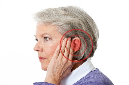 Senior woman touching her ear due to ear discomfort, possibly caused by earwax buildup or tinnitus