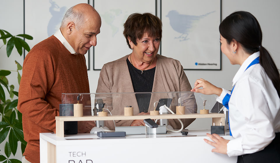 Older couple learning about hearing aid options from a hearing care professional.