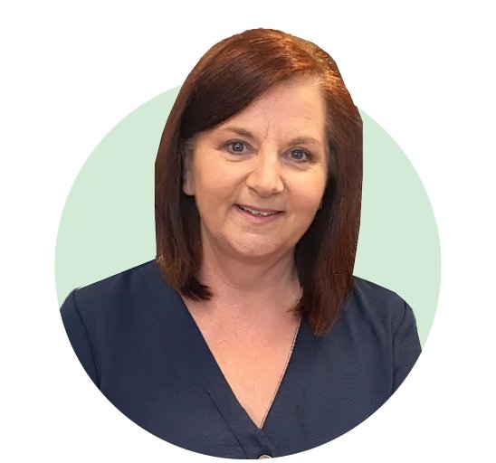 A woman with shoulder-length auburn hair wears a navy blue V-neck top, set against a pastel green circular background. Her face is blurred, leaving her identity unrecognizable. No text is visible.