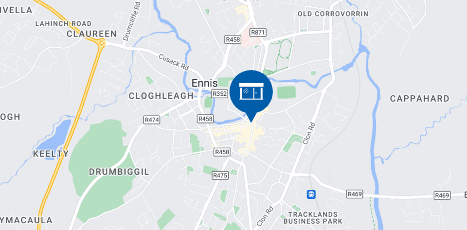 A detailed map highlights the town of Ennis in County Clare, Ireland, featuring a blue icon with hearing-related symbols marking the location of a Hidden Hearing clinic. Surrounding areas like Claureen, Cloghleagh, and Cappahard are labeled, with visible main roads (R458, R469) and landmarks such as Tracklands Business Park. No additional text or hearing aid brands are identified.