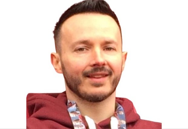A person wearing a maroon hoodie with a patterned drawstring is set against a plain white background. Their facial features are blurred, and no hearing aids, text, or identifiable brand logos are visible.
