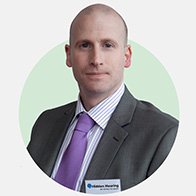 male audiologist wearing a suit with a name badge