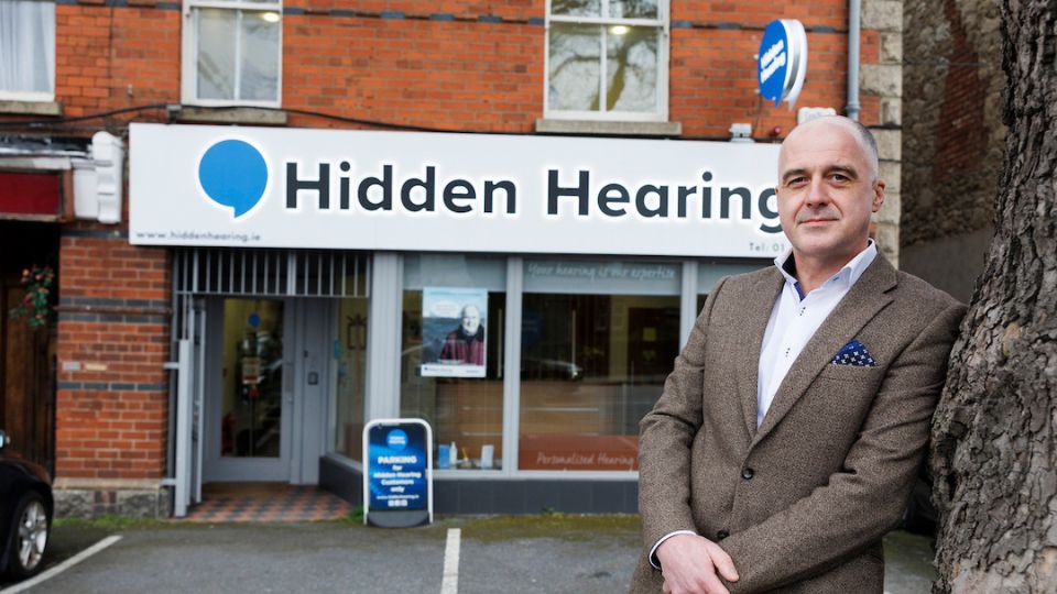 A photograph of audiologist Enda Dooley standing outside the Hidden Hearing Ballsbridge clinic