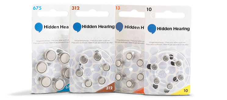 Four packs of hearing aid batteries from Hidden Hearing, labeled 675, 312, 13, and 10, arranged side by side. Each blister pack showcases round silver batteries, with corresponding color-coded packaging: blue (675), brown (312), orange (13), and yellow (10). The packaging includes text in multiple languages: 'Hörgerätezellen | Piles pour aides auditives | Pilas para audífonos.'