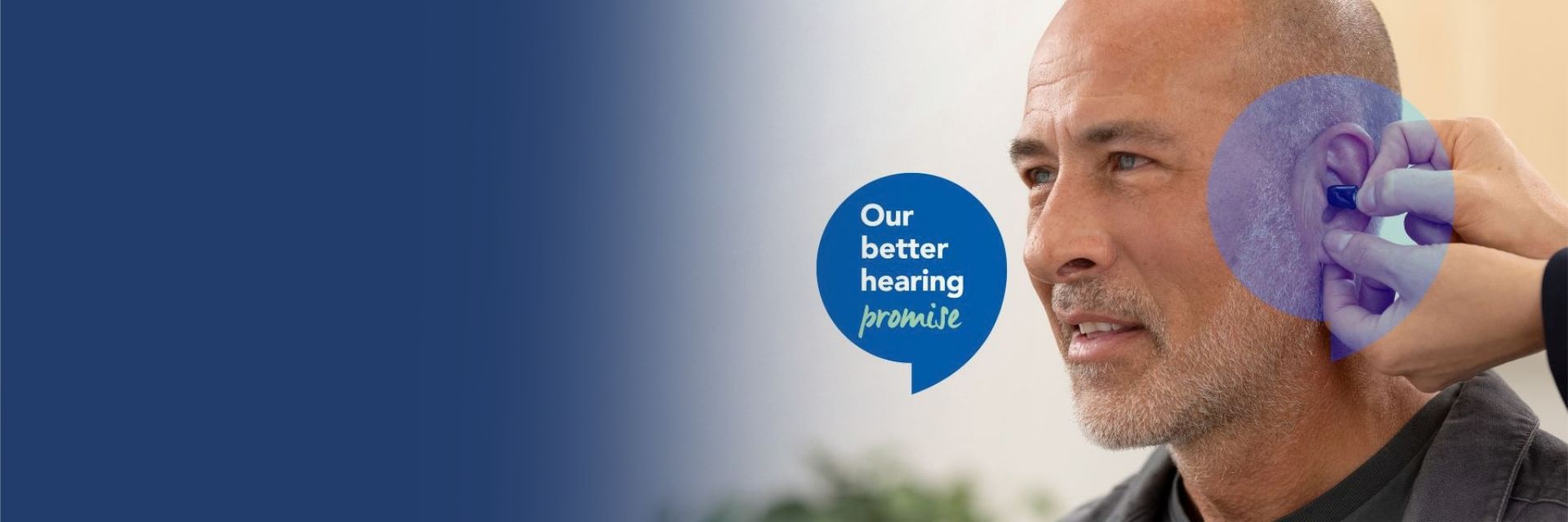 A man getting an Oticon Zeal hearing aid fitted with a speech bubble in front of him talking about the Hidden Hearing Better Hearing Promise