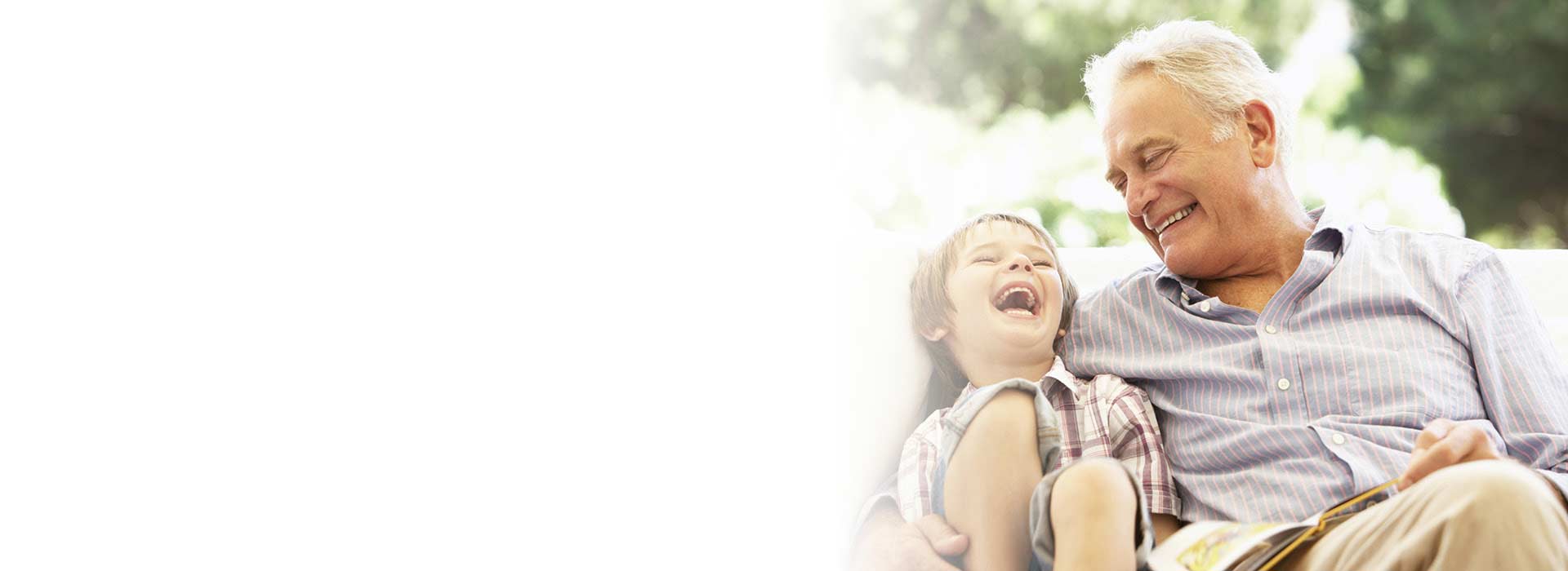 child smiling while spending time with an older man outdoors