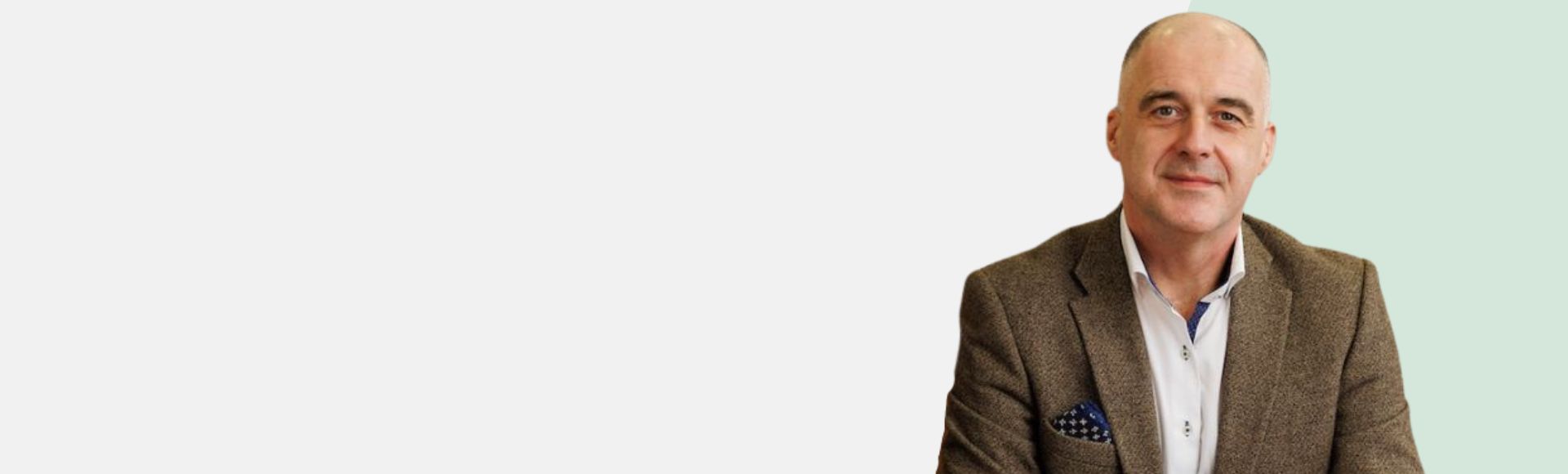 Audiologist Enda Dooley in a brown blazer with a light green background