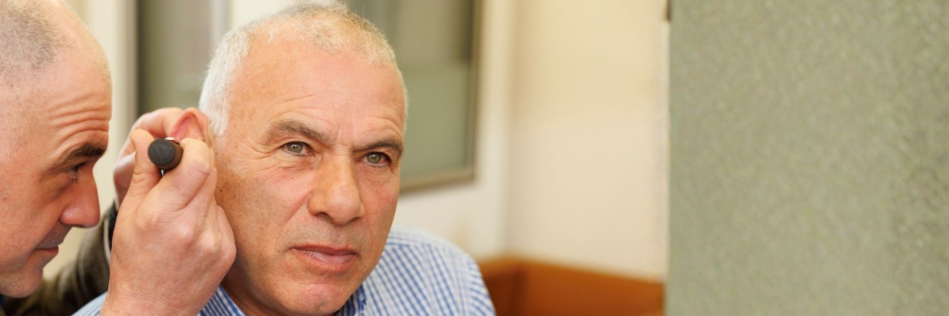 Man getting an diagnostic examination using an otoscope