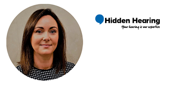 [GEN] A person with blurred facial features is framed within a circular design, wearing a black-and-white polka-dot top. On the right side, the Hidden Hearing logo appears, featuring a blue speech bubble icon alongside the text: 'Hidden Hearing - Your hearing is our expertise.' The image represents a hearing clinic specializing in hearing tests and audiologist services.