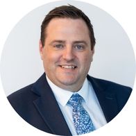 A headshot of Hidden Hearing audiologist Alan Johnston smiling in a suit