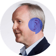 A photograph of Hidden Hearing audiologist David Courtney with a blue speech bubble overlayed on his ear