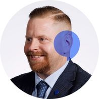 A picture of Hidden Hearing audiologist Ger Dowling smiling with a blue speech bubble overlayed on his ear