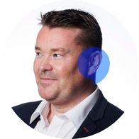 Hearing Aid Audiologist Mark Hayes smiling with a blue Hidden Hearing logo overlayed on his ear
