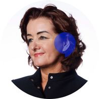A photograph of audiologist Antoinette Gallagher smiling with a blue speech bubble over her ear