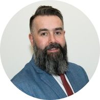 A photograph of hearing aid audiologist Daryl Burrowes smiling in a suit