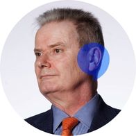 A photograph of hearing aid audiologist Gavin Johnson with a blue speech bubble overlayed over his ear