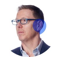 A photograph of hearing aid audiologist Graham Holmes with a blue speech bubble overlayed over his ear
