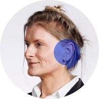 A photograph of audiologist Zoe Fletcher smiling with a blue speech bubble over her ear